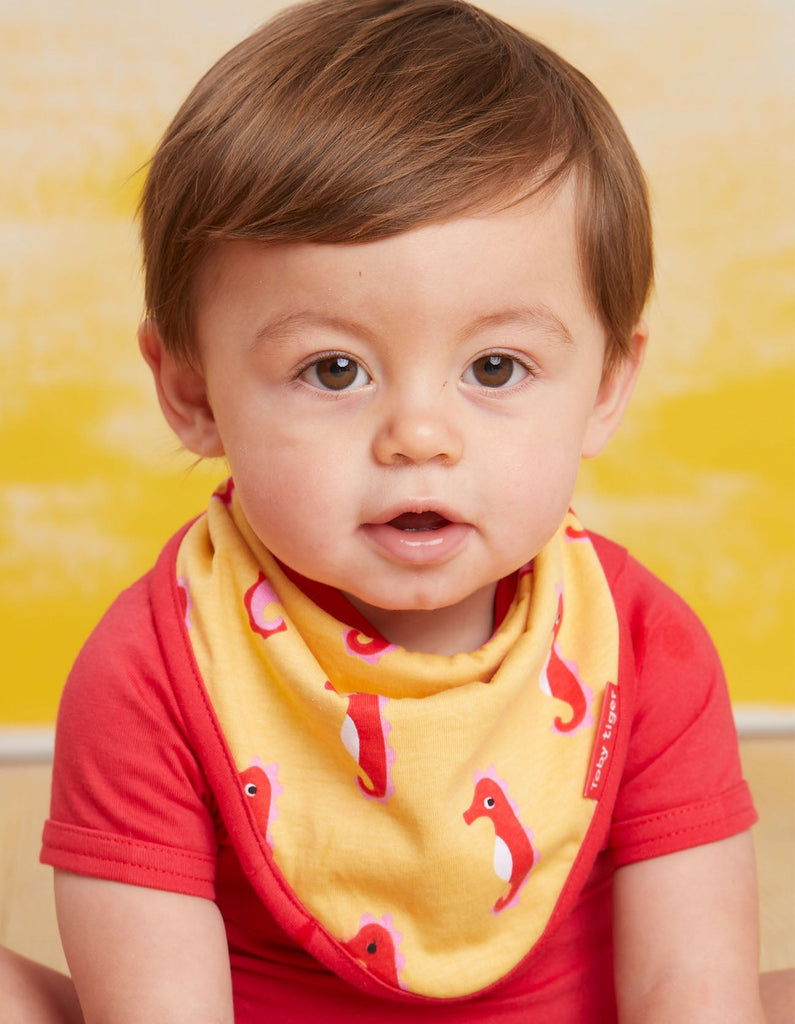 Toby Tiger Seahorse Dribble Bib - A gorgeous bib in yellow featuring sweet seahorses with a bold red trim. Sold by Say It Baby Gifts