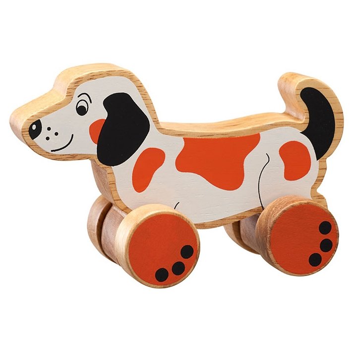 Lanka Kade Dog Push Along Toy. A chunky wooden sausage dog toy push along. This orange and white dog is handcrafted from sustainable rubber wood and is perfect for small hands - great for imaginative play.