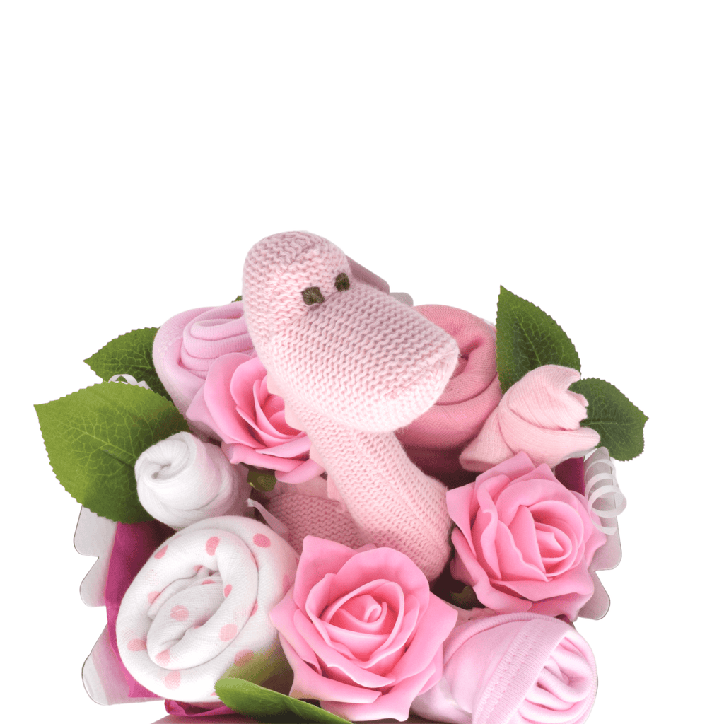 Say It Baby - Sweet Baby Pink Dino Bouquet. The bouquet box contains muslin squares, baby bibs, socks and a gorgeous Best Years Diplodocus Dino in pink. The sweet dino is made from organic cotton and features a gentle rattle.