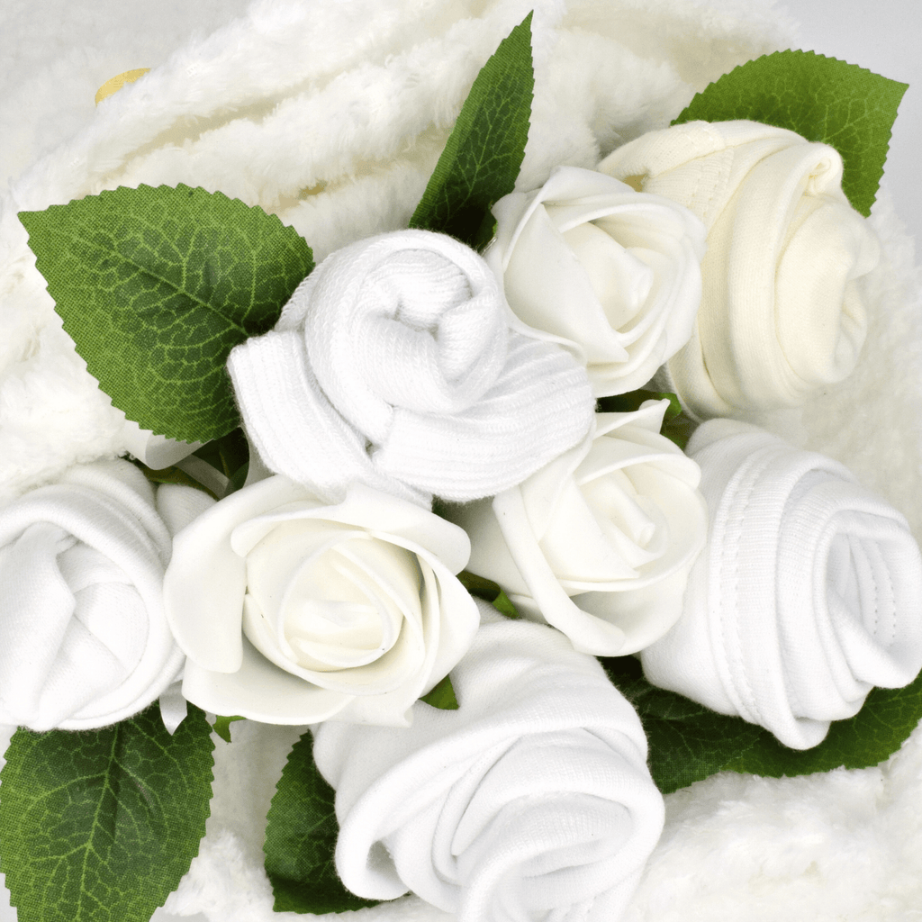 Say It Baby Traditional Baby White Clothes Bouquet. Our Traditional Baby White Clothes Bouquet is carefully crafted out of soft 100% cotton baby clothes. This bouquet contains baby bibs, socks, hat and bodysuit and wrapped in a white baby blanket.
